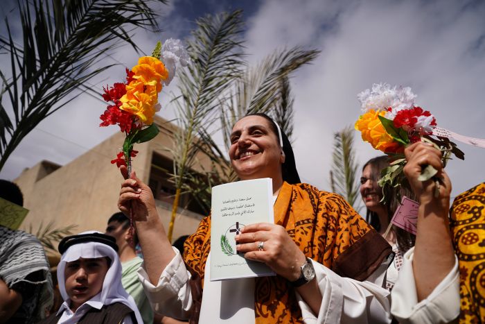 När de gick genom gatorna i Qaraqosh i Irak den 13 april 2025 sjöng deltagarna palmsöndagspsalmer på både arabiska och syriska, viftade med olivkvistar och många bar traditionella kläder från Qaraqosh och andra kristna städer och byar i Irak.