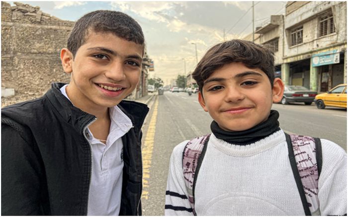 Två unga pojkar, Iraks framtid, poserar för ett foto.