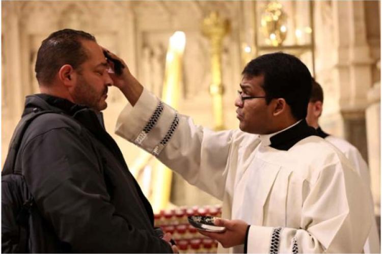 Människor får aska i pannan på askonsdagen, som markerar början på fastan, i St. Patrick's Cathedral i New York City, USA, den 5 mars 2025.
