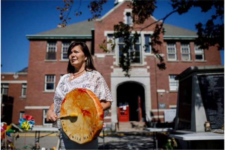 Kukpi7-chefen, Rosanne Casimir, från Tk'emlúps te Secwépemc poserar på platsen för ett provisoriskt minnesmärke vid den tidigare Kamloops Indian Residential School i Kamloops, Kanada.
