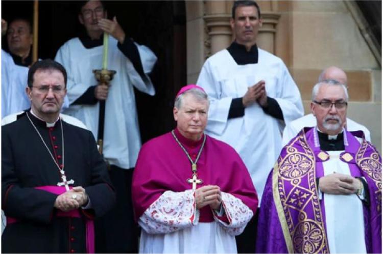 Ärkebiskopen av Sydney, Anthony Fisher (i mitten) och andra präster väntar på ankomsten av kardinal George Pells kista i St Mary's Cathedral, Sydney, Australien, den 1 februari 2023.