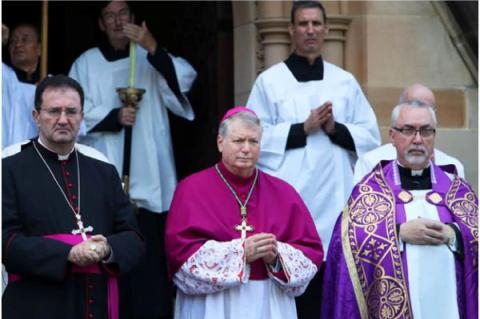 Ärkebiskopen av Sydney, Anthony Fisher (i mitten) och andra präster väntar på ankomsten av kardinal George Pells kista i St Mary's Cathedral, Sydney, Australien, den 1 februari 2023.
