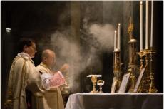En katolsk präst firar den traditionella latinska mässan med en diakon och subdiakon och incenserar altaret i Sankt Pancratiuskyrkan i Rom